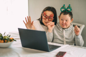 An older person with intellectual and developmental disabilities with a women engaging with others on a computer screen